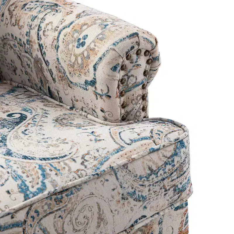 Fauteuil rembourré en bois avec motif floral, accoudoirs à panneaux et dossier en forme de bosse de chameau.